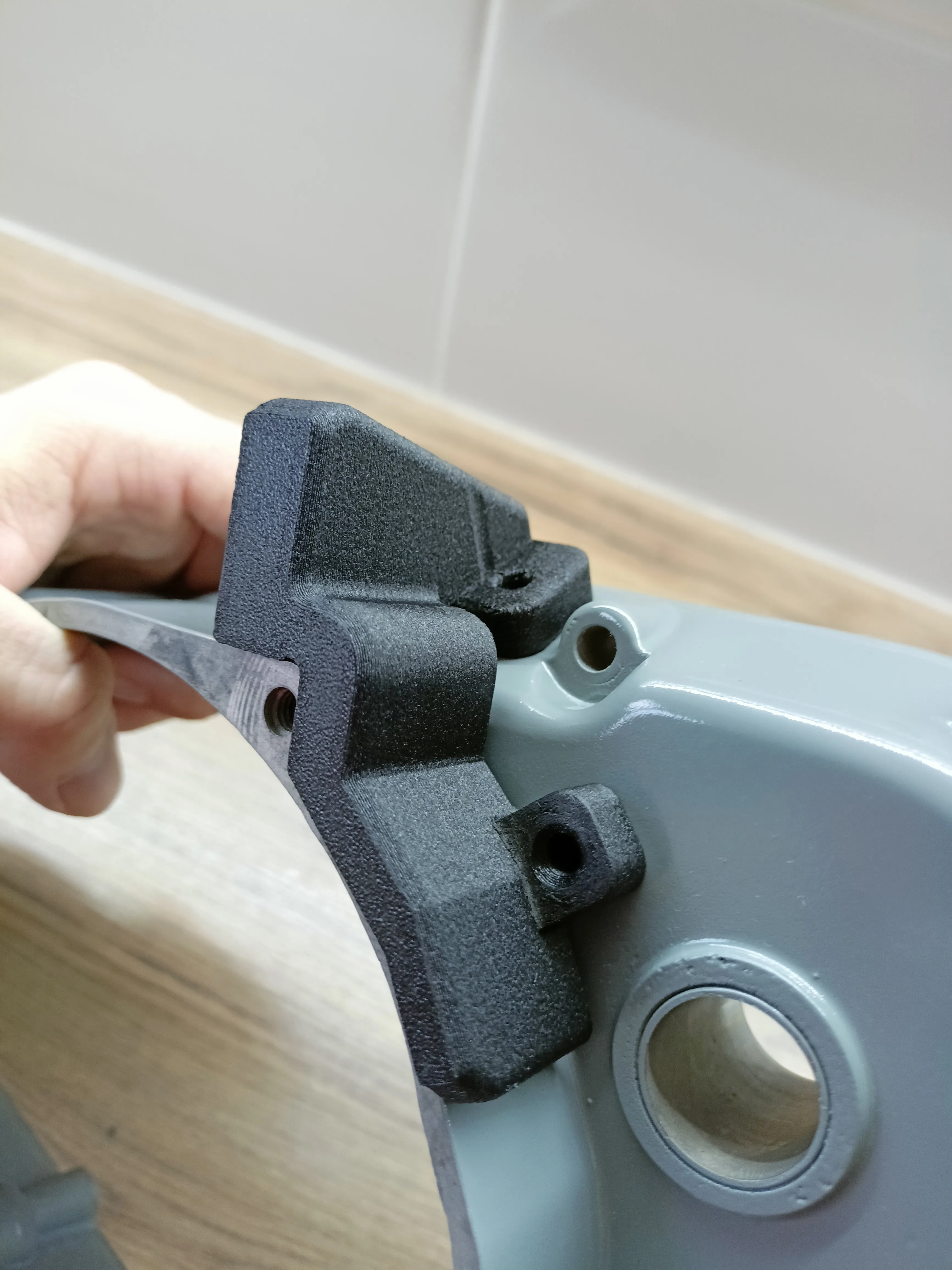 Vytištěný náhradní díl přiložený k původnímu krytu stroje